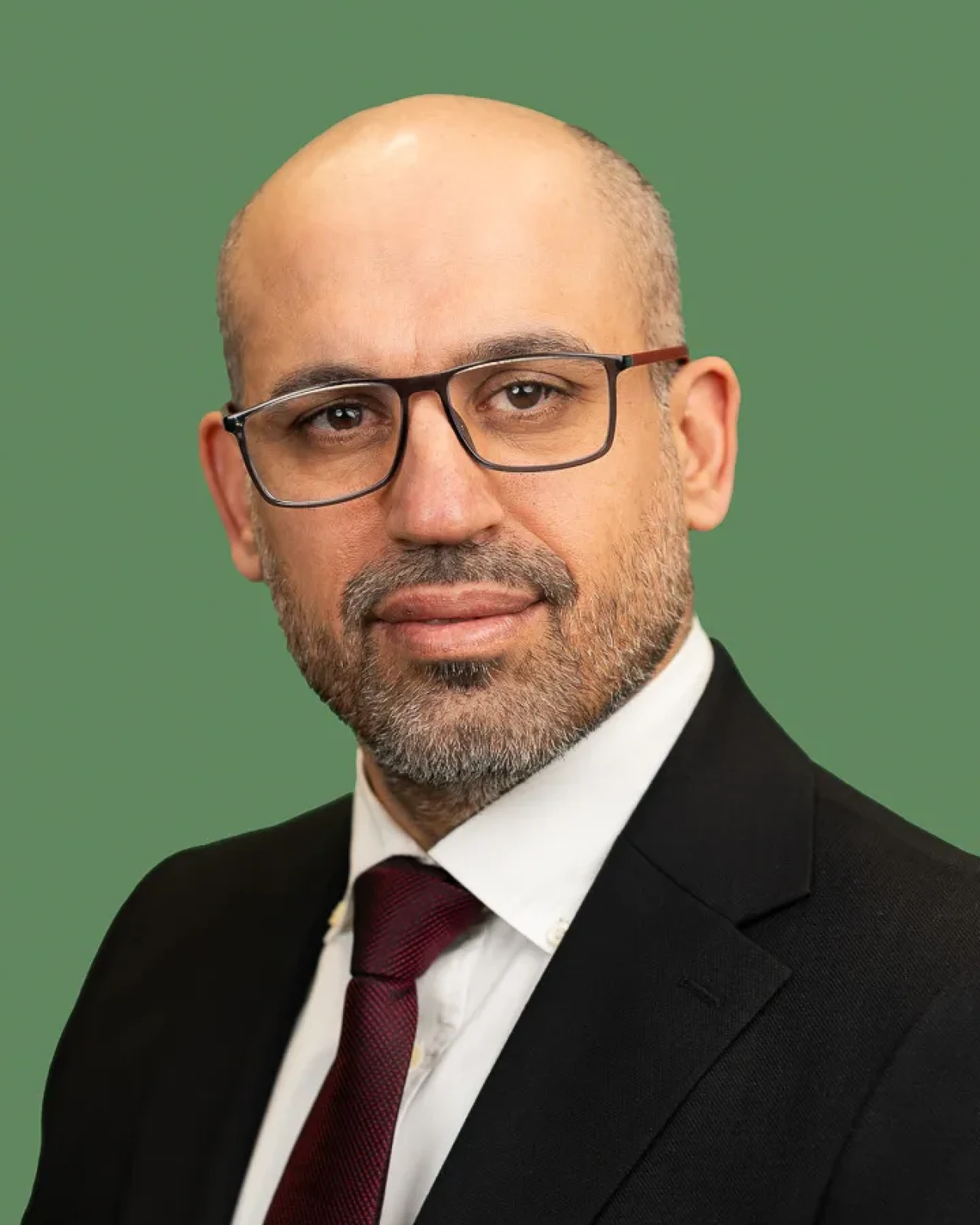 Smart man looking at camera on a green background. Smart man looking at camera on a green background.